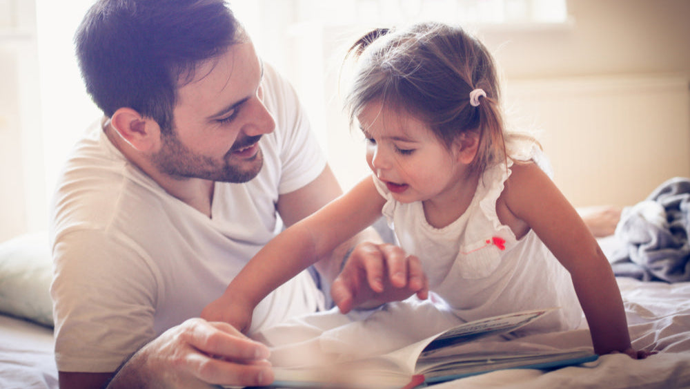 Vater liest Tochter im Bett vor