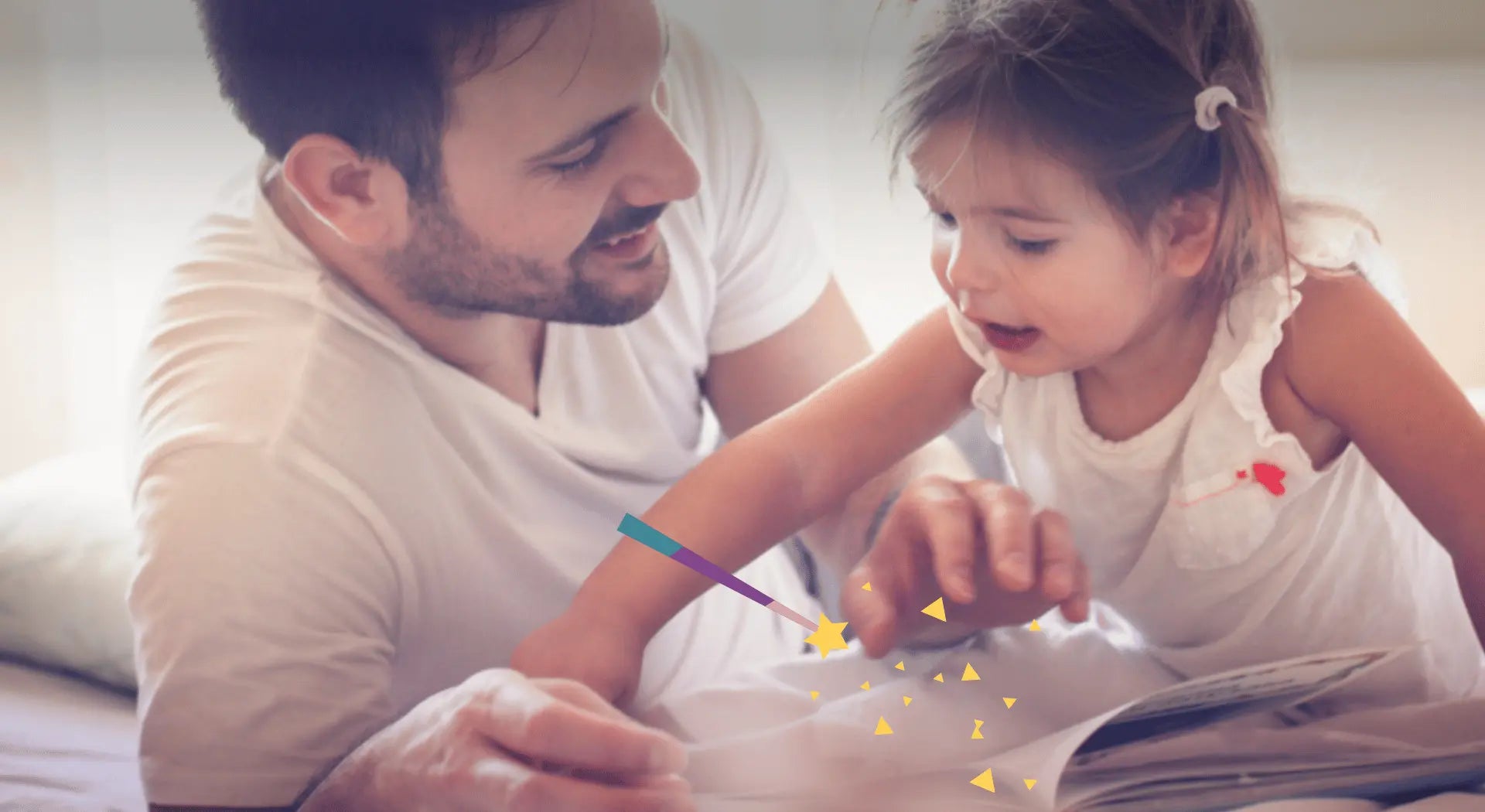 Ein Papa schaut gemeinsam mit seiner Tochter ein Buch an.