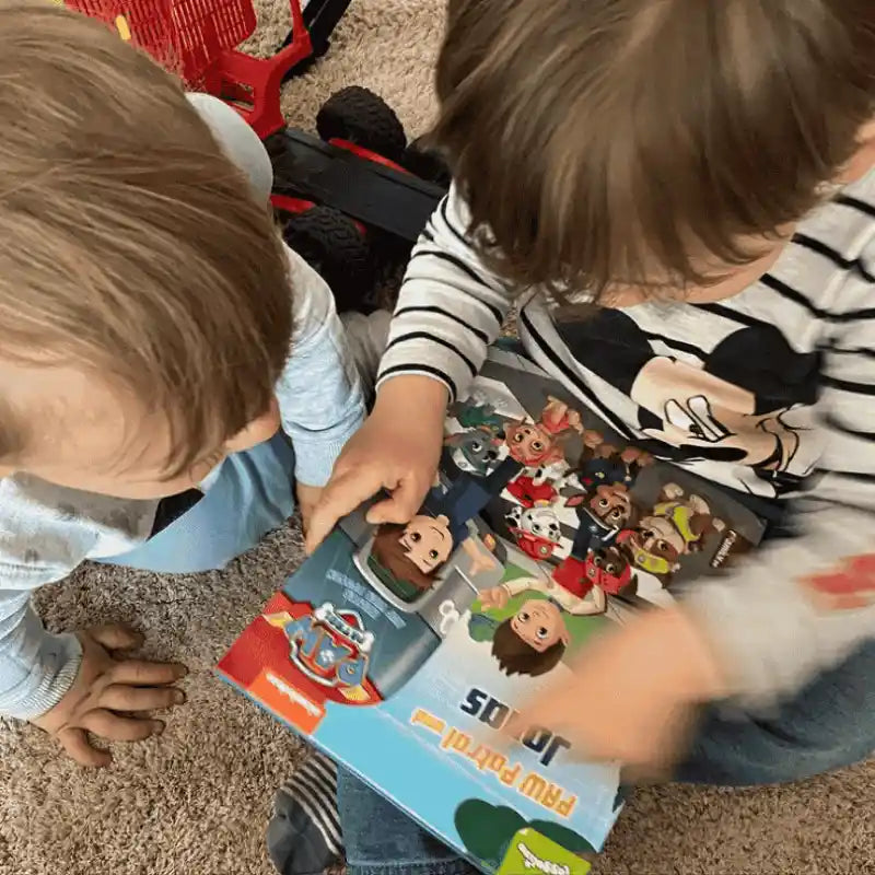 Zwei kleine Kinder gucken sich ein Paw Patrol Buch an