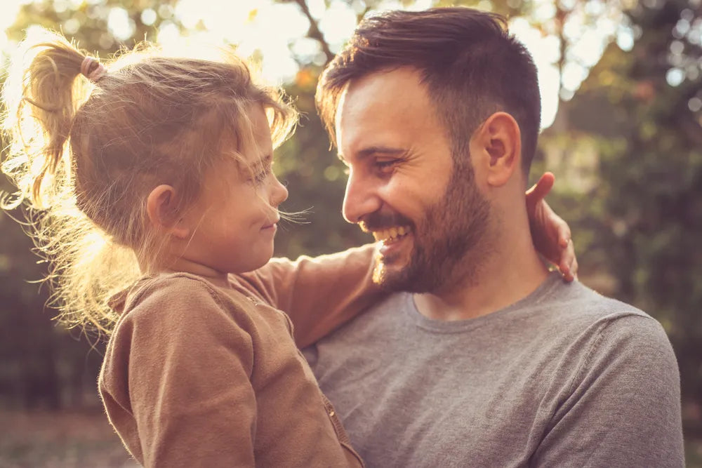 Vater und Tochter lächeln sich an